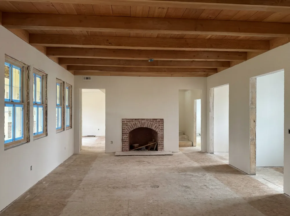 Arched fireplace of reclaimed brick beneath exposed beams