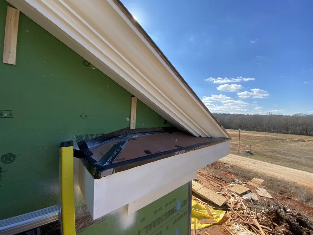 Hand-run cornice and soffit detail against the sky