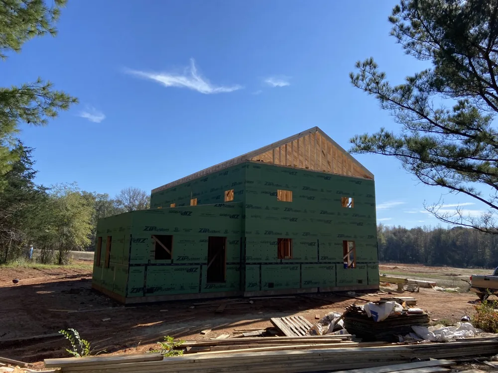 The house at framing stage under a deep blue sky