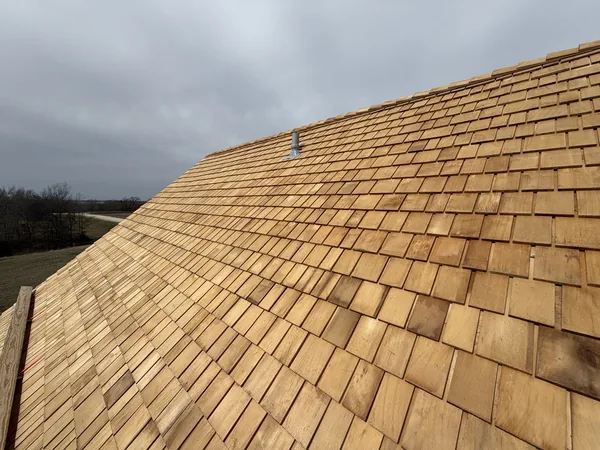 Fresh cedar shingles laid by hand on a steep roof